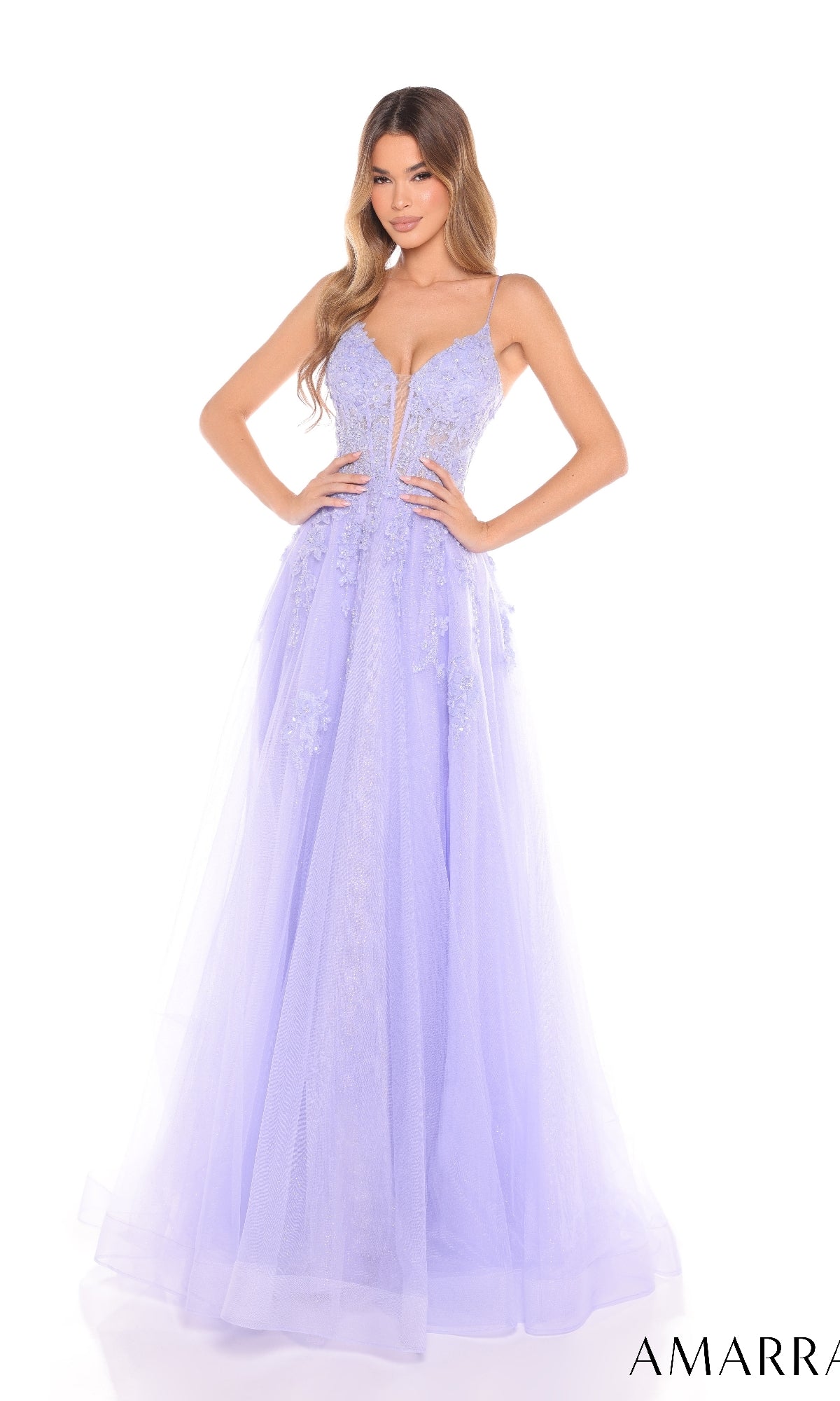 A woman stands with hands on hips against a white background, wearing the Amarra 88253 long prom dress featuring thin straps, glitter tulle, floral embellishments, and a deep V-neckline in light purple.